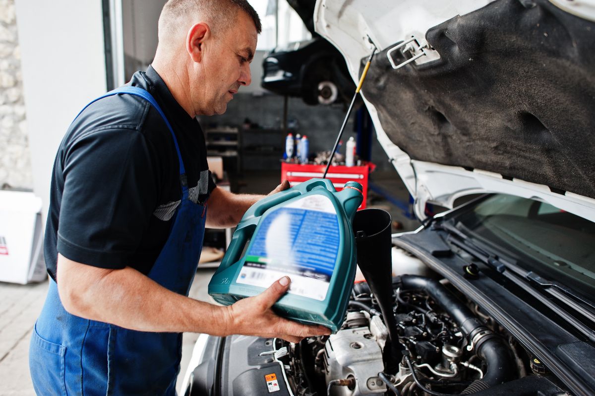Mechanic pouring fresh motor oil